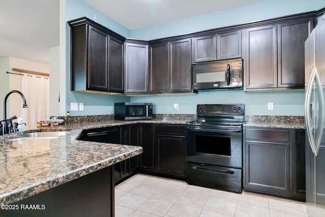 kitchen featuring dark brown cabinetry, sink, black appliances, and dark stone counters