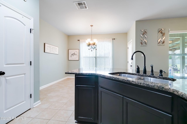 kitchen with sink, light tile patterned floors, plenty of natural light, and hanging light fixtures