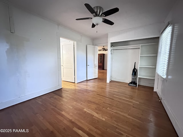 unfurnished bedroom featuring wood-type flooring, a closet, and ceiling fan