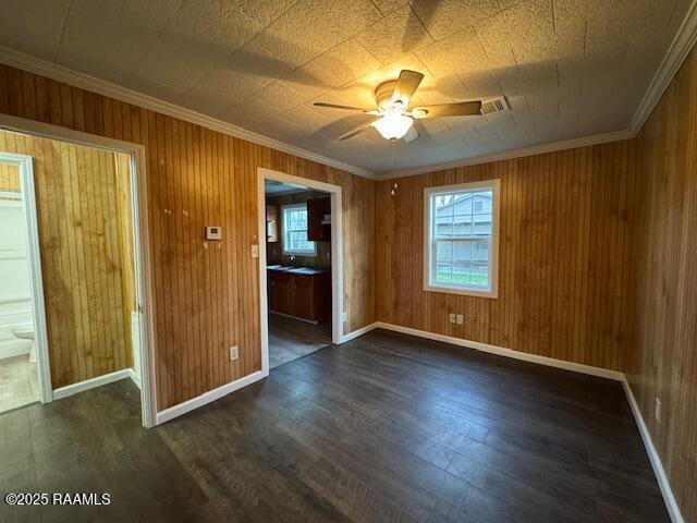 unfurnished room featuring ceiling fan, dark hardwood / wood-style flooring, and ornamental molding