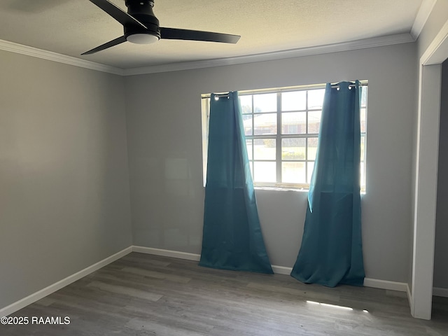 unfurnished room with baseboards, a ceiling fan, crown molding, and wood finished floors