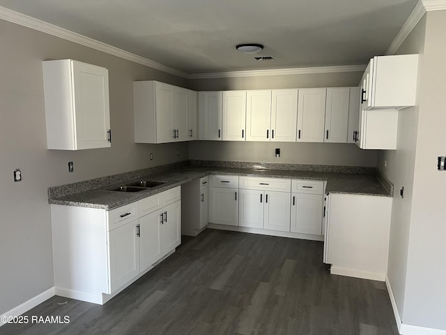 kitchen featuring a sink, dark wood finished floors, white cabinets, and crown molding