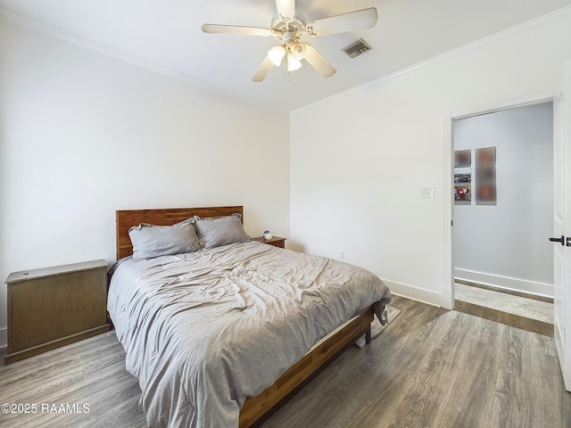 bedroom featuring hardwood / wood-style flooring, ceiling fan, and crown molding