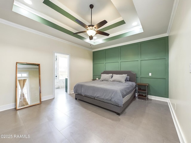 bedroom featuring light tile patterned floors, crown molding, ensuite bath, and a raised ceiling