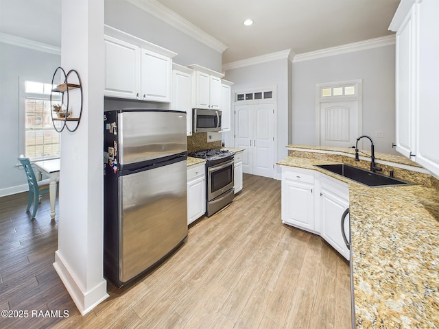 kitchen featuring white cabinetry, stainless steel appliances, light hardwood / wood-style floors, and sink