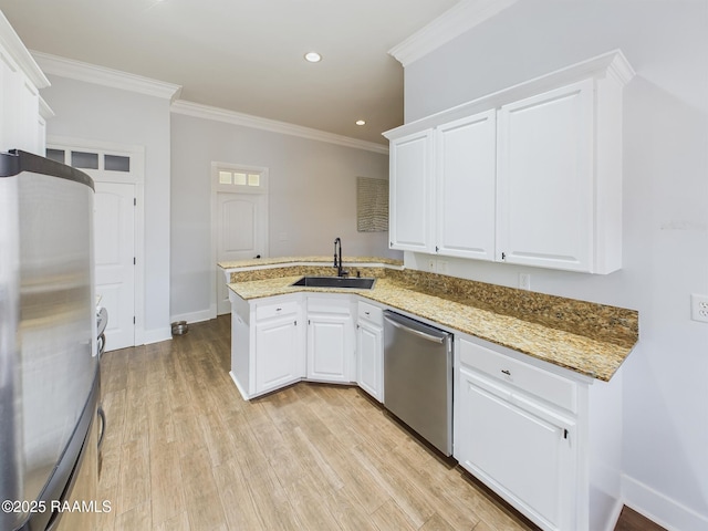 kitchen featuring appliances with stainless steel finishes, kitchen peninsula, sink, and white cabinets