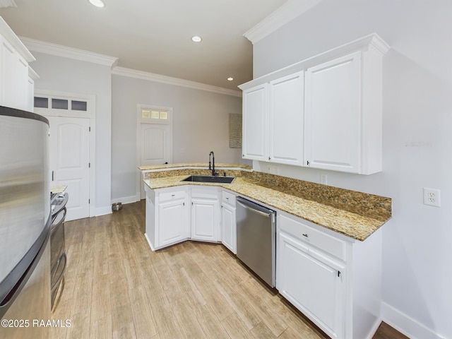 kitchen with stainless steel appliances, kitchen peninsula, sink, and white cabinets