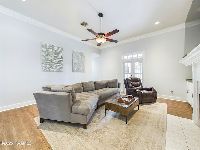 living room with ceiling fan, ornamental molding, and light wood-type flooring