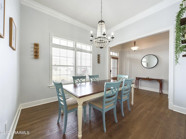 dining area with dark wood-type flooring, ornamental molding, and a chandelier