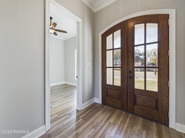 entryway with french doors, ceiling fan, ornamental molding, and wood-type flooring