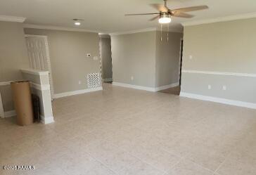 unfurnished living room with ornamental molding and ceiling fan