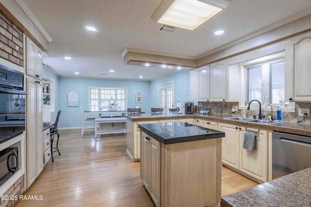 kitchen with sink, light wood-type flooring, dishwasher, and a center island