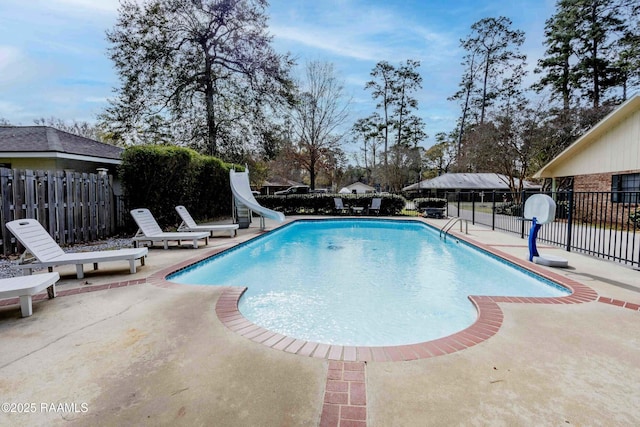 view of swimming pool with a patio area and a water slide