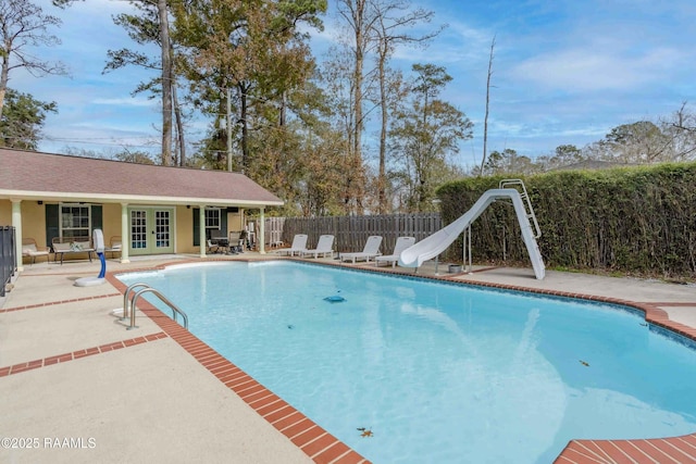 view of pool with a patio, an outdoor structure, and a water slide