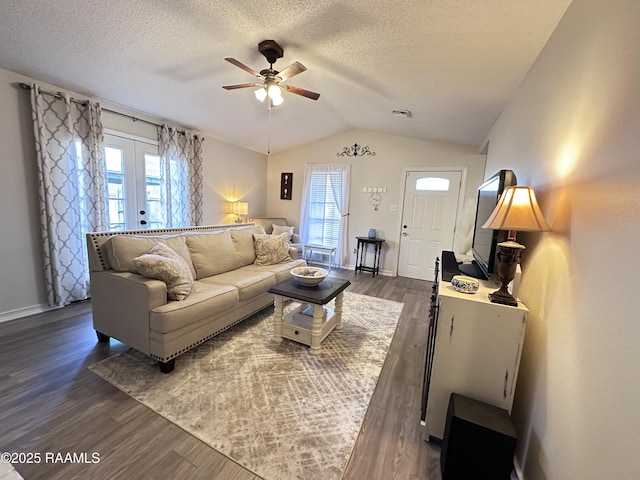 living room with vaulted ceiling, ceiling fan, plenty of natural light, and dark hardwood / wood-style floors