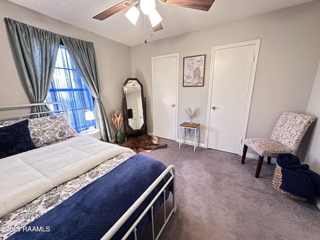 bedroom featuring a textured ceiling, ceiling fan, and dark carpet