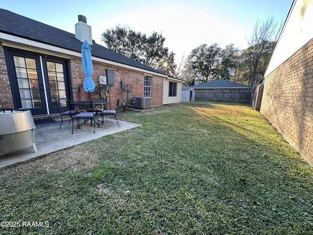 view of yard with central AC and a patio