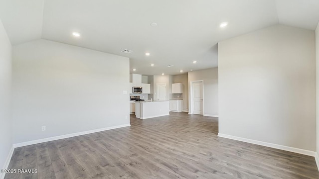 unfurnished living room with vaulted ceiling and light hardwood / wood-style flooring