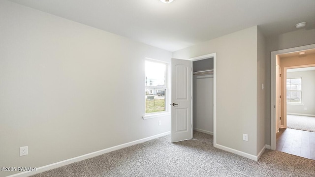 unfurnished bedroom with multiple windows, a closet, and carpet