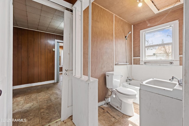 full bathroom featuring shower / washtub combination, toilet, vanity, and wood walls