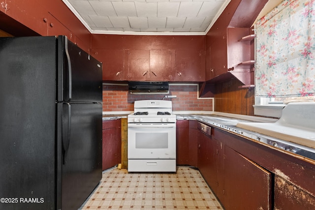 kitchen with range hood, white gas range oven, and black fridge