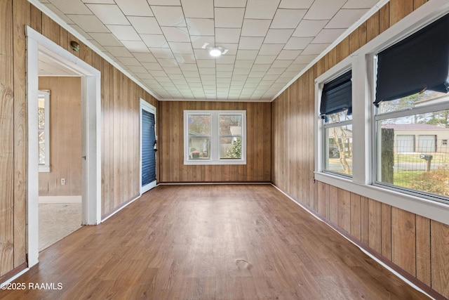 empty room featuring hardwood / wood-style floors and wooden walls