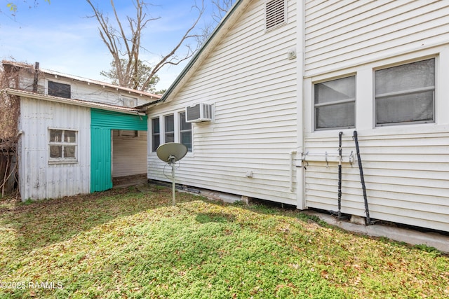 view of property exterior featuring a wall mounted air conditioner and a lawn