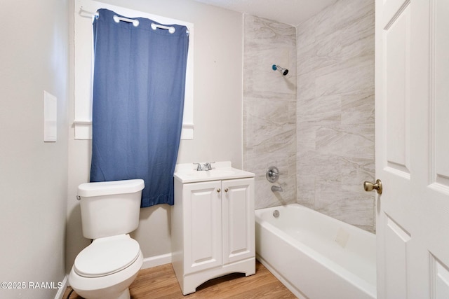 full bathroom with hardwood / wood-style floors, toilet, vanity, and tiled shower / bath combo