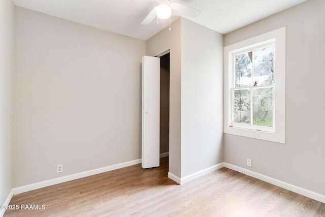 unfurnished bedroom featuring light wood-type flooring, ceiling fan, and multiple windows