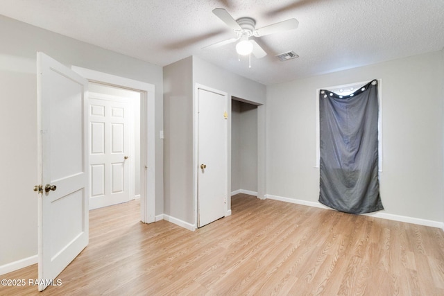 unfurnished bedroom with ceiling fan, a textured ceiling, and light hardwood / wood-style floors