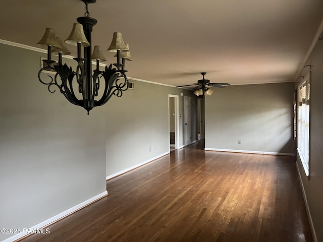 spare room with dark wood-type flooring, crown molding, and ceiling fan with notable chandelier