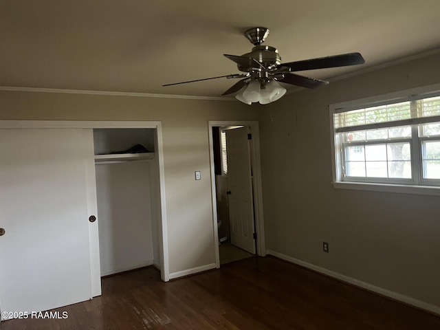 unfurnished bedroom with ceiling fan, dark hardwood / wood-style flooring, a closet, and ornamental molding