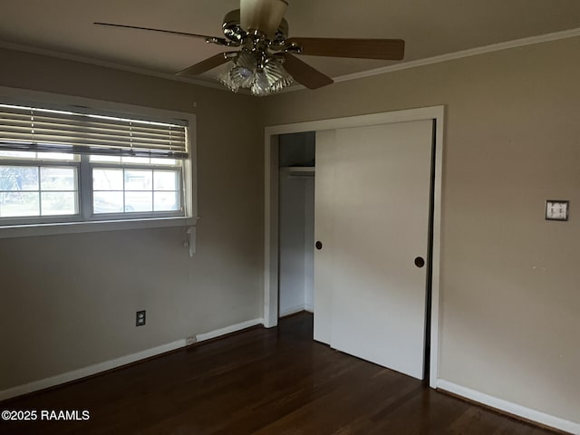 unfurnished bedroom with ceiling fan, a closet, dark hardwood / wood-style floors, and ornamental molding