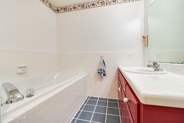 bathroom featuring vanity, tile patterned flooring, and tiled bath