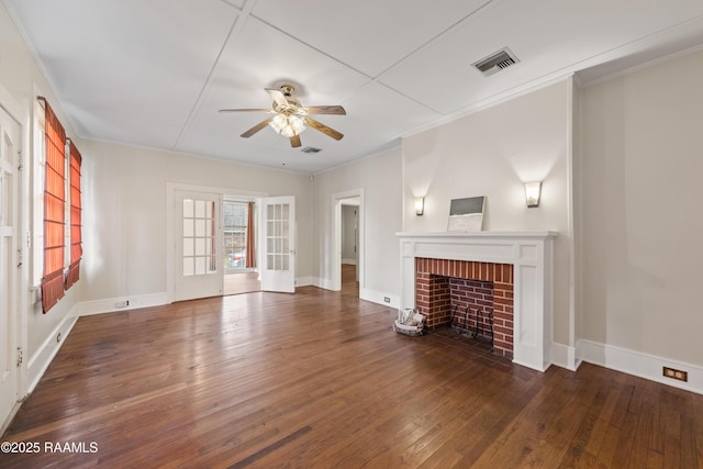 unfurnished living room with ceiling fan, a fireplace, dark hardwood / wood-style floors, ornamental molding, and french doors