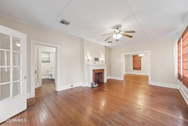 unfurnished living room with ceiling fan, a fireplace, and dark hardwood / wood-style floors