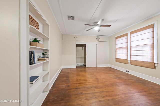 unfurnished room featuring ceiling fan, hardwood / wood-style floors, and built in shelves