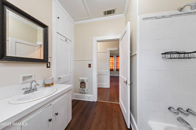 bathroom with vanity, hardwood / wood-style floors, crown molding, heating unit, and shower / bathtub combination