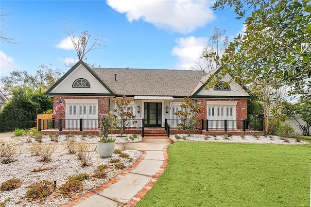 view of front of house with french doors, brick siding, and fence