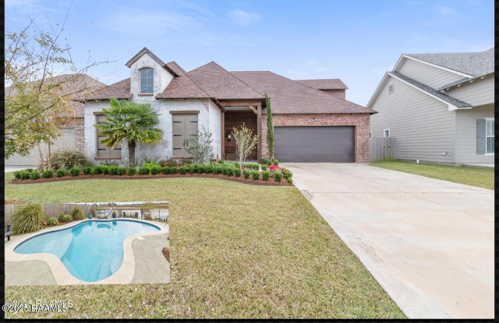 view of front of house with a garage, a fenced in pool, and a front yard