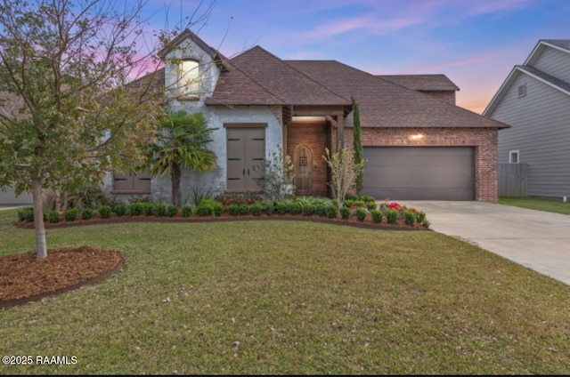 view of front of home with a yard and a garage