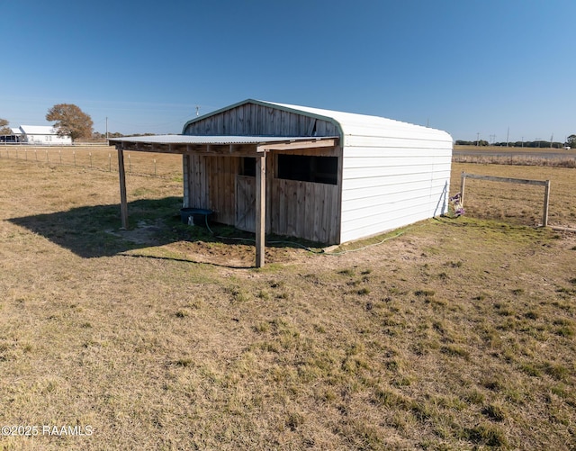 view of outdoor structure featuring a lawn and a rural view