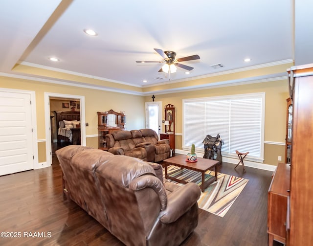 living room with dark hardwood / wood-style flooring, a tray ceiling, ornamental molding, and ceiling fan