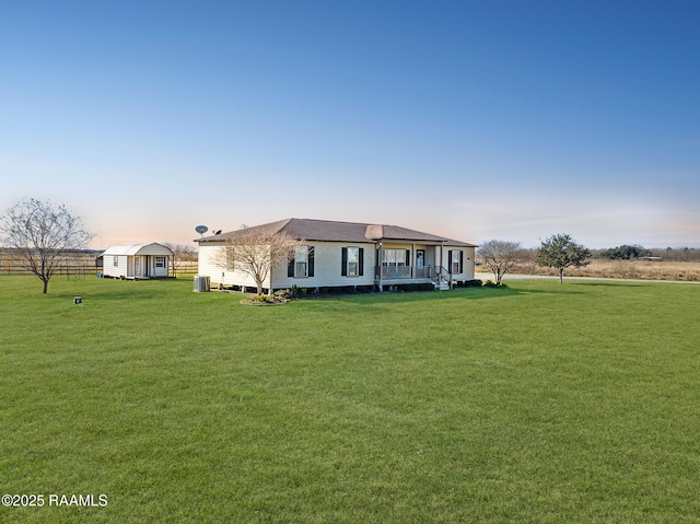 ranch-style home with a yard and a storage shed