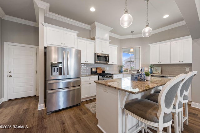 kitchen featuring a center island, white cabinetry, hanging light fixtures, light stone countertops, and appliances with stainless steel finishes