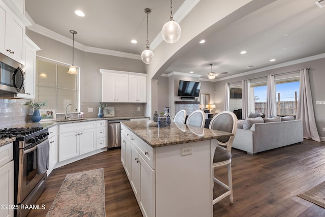 kitchen featuring a kitchen island, appliances with stainless steel finishes, and white cabinetry