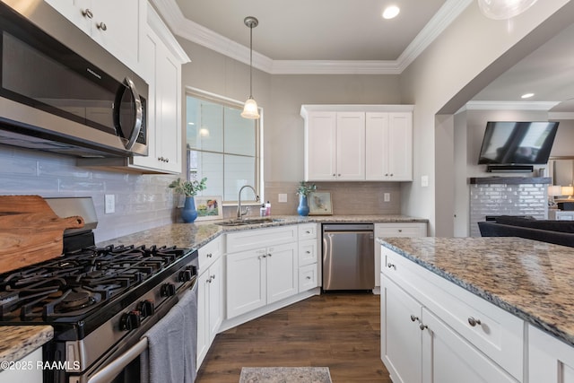 kitchen with light stone counters, stainless steel appliances, white cabinets, and sink