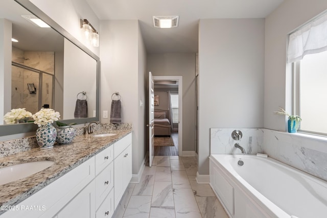 bathroom featuring vanity, a wealth of natural light, and plus walk in shower