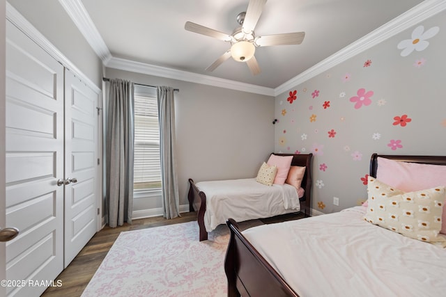 bedroom featuring ceiling fan, dark wood-type flooring, ornamental molding, and a closet