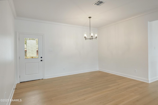 spare room with an inviting chandelier, ornamental molding, and light hardwood / wood-style floors